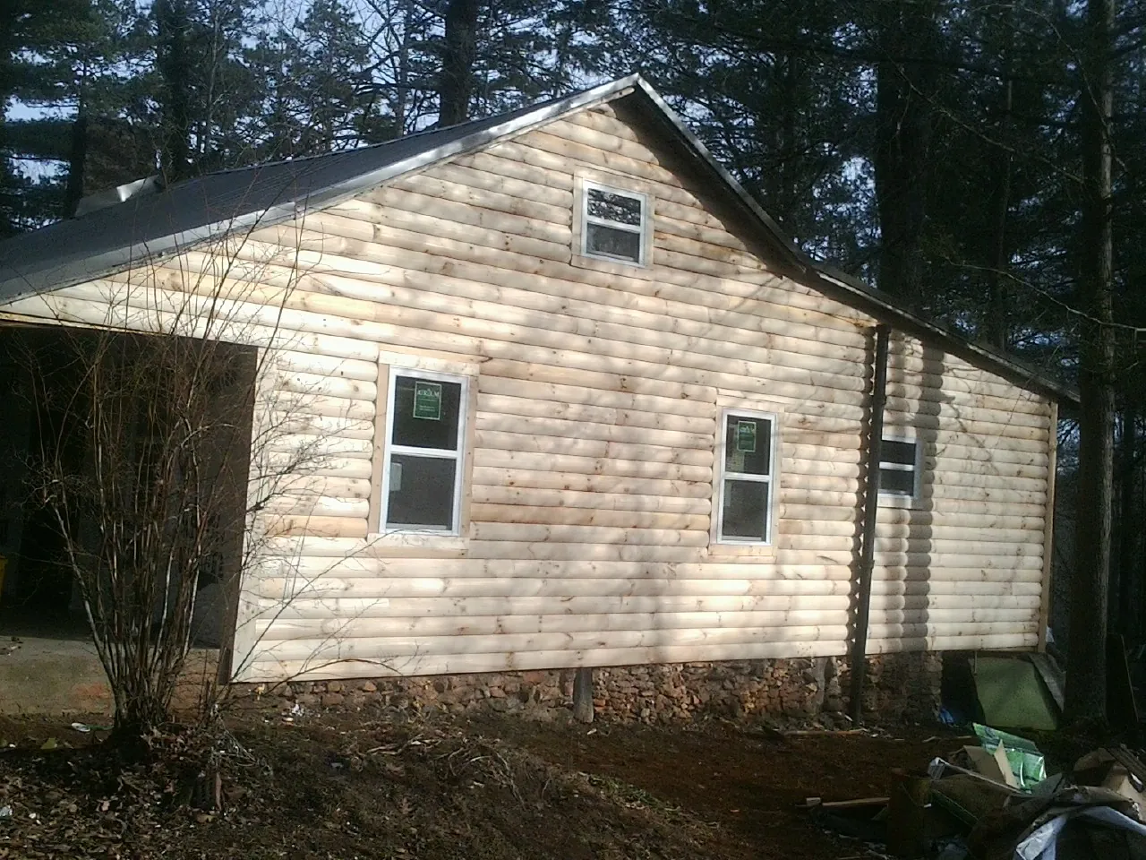 New log siding and dark metal roofing on a gable end in Fredericksburg