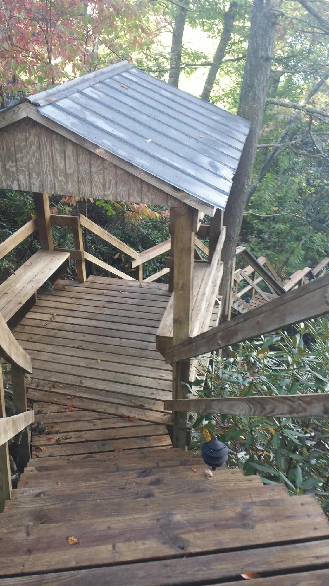 Metal roofed shelter over wooden steps on a wooded walkway — Skylight Repair & Installation work by our crew in Fredericksburg